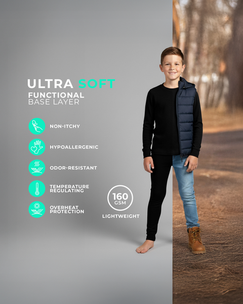 A boy wearing a black long-sleeve base layer top and leggings, shown barefoot against a split studio and fall outdoor background with icons highlighting non-itchy, hypoallergenic, odor-resistant, and temperature regulating features of 160 GSM fabric.