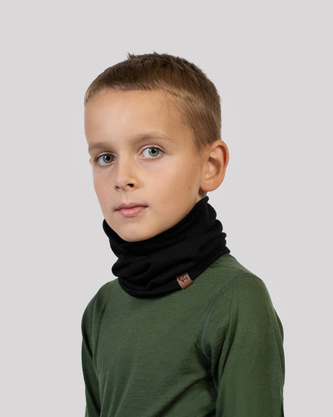 Boy wearing a black Merino wool neck gaiter – multifunctional kids’ scarf ideal for layering in winter.