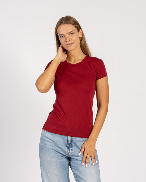 Woman wearing a merino wool menique royal cherry t-shirt and denim jeans standing in white background.