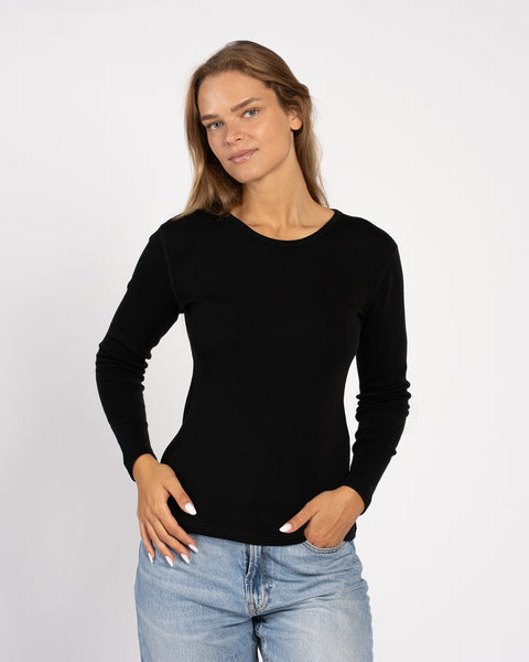 Model wearing women’s black Merino wool crew – slim fit thermal long sleeve
