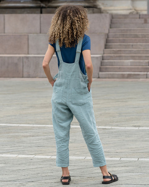 Gorgeous woman posing from the back, in a city, wearing mint green linen Jumpsuit Nicci.