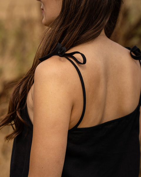 Young woman wearing black linen dress with open back