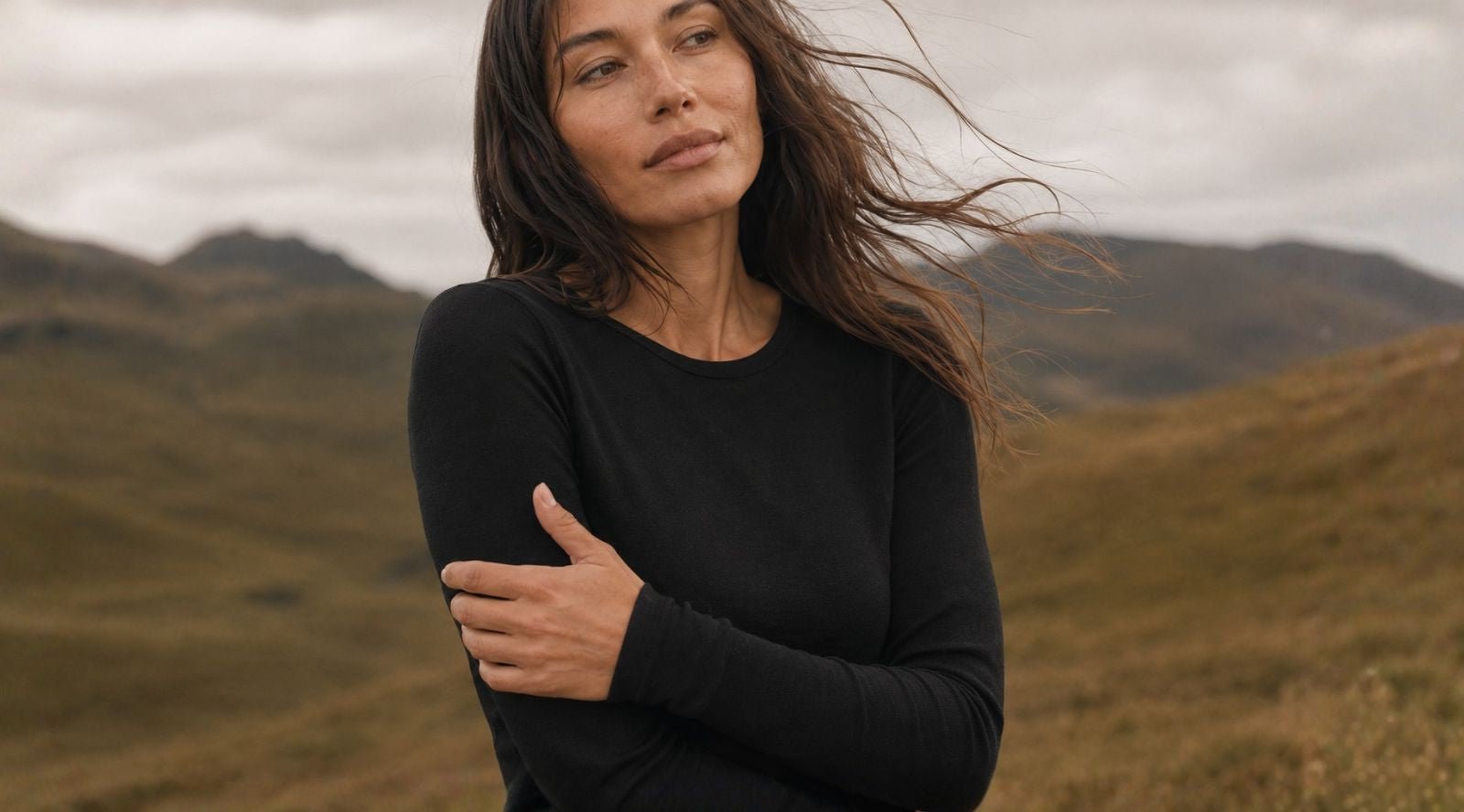 In the picture you can see a woman standing in her house, her face is not showing. She is wearing a royal cherry red color long-sleeve top with matching leggings made from natural 100% Merino wool.