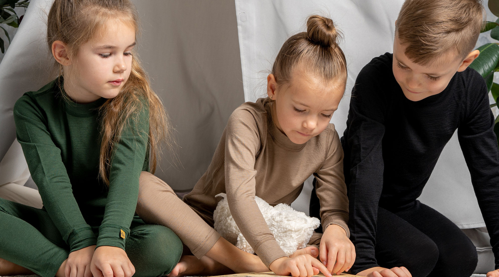 a girl sitting in a mustard yellow armchair, wearing a royal cherry color clothing set made from merino wool fabric.