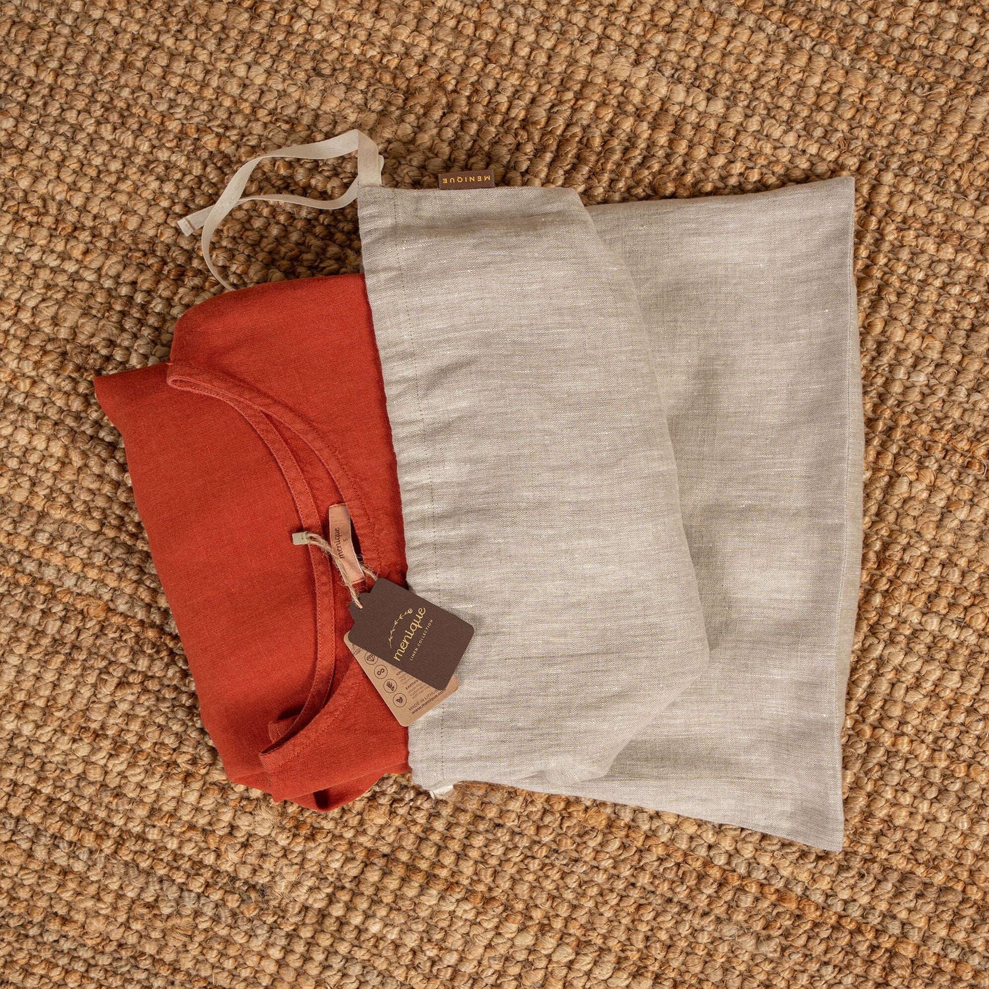 A woman holding a small natural linen storage bag in her palm, putting a kids' toy part inside the bag.