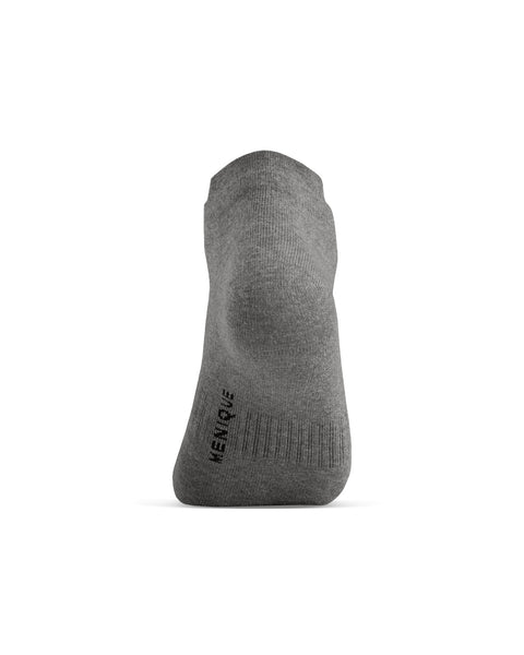 A back view of a gray ankle sock on a foot model, showing the heel and the word "MENIQUE" printed vertically on the lower back portion.
