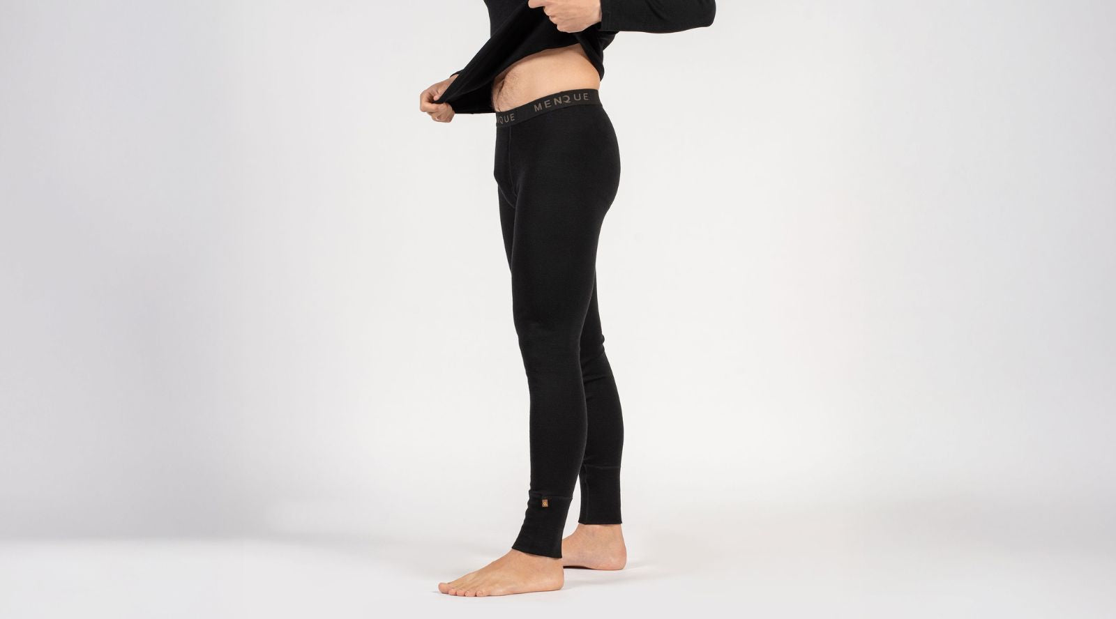 Person wearing black compression leggings on a white background