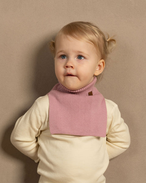 Little girl wearing merino wool natural pants and long sleeve top with candy pink cotton dickie and socks