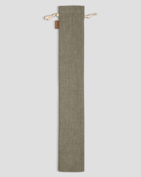 Long, stone green linen fabric pouch with drawstrings on a light gray background