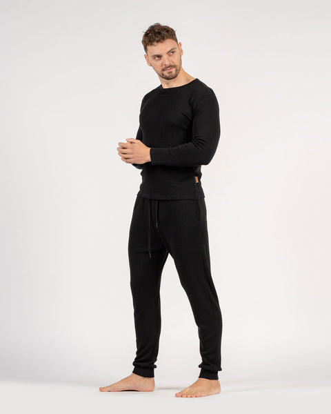 The menique men&#39;s merino wool 250gsm long sleeve top and jogger sweatpants set in black color.