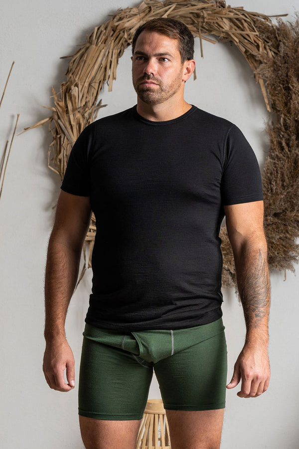 A man wearing the menique men's boxer underwear in color dark green.