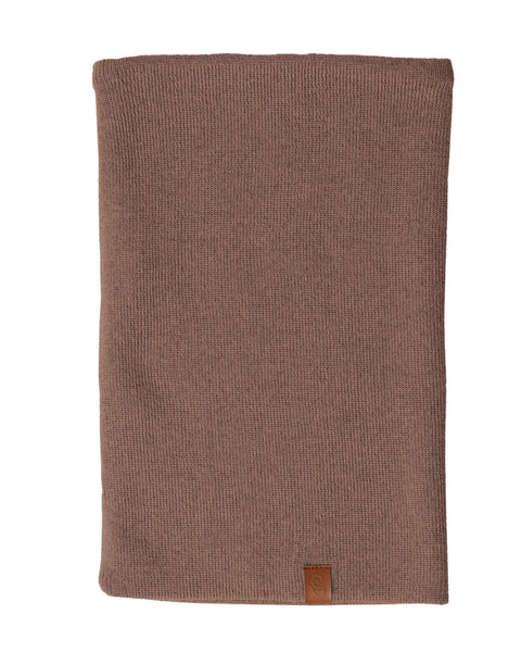 A brown knit neck gaiter, likely made of merino wool, is displayed against a white background. The gaiter is shown laid flat and has a small brown tag at the bottom.