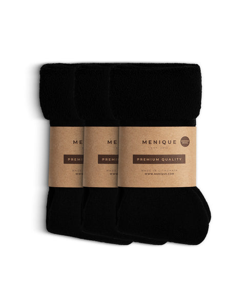 Three pairs of women’s black sherpa fleece socks, folded and wrapped in eco-friendly Menique brown paper bands labeled ‘Premium Quality – Merino Wool.