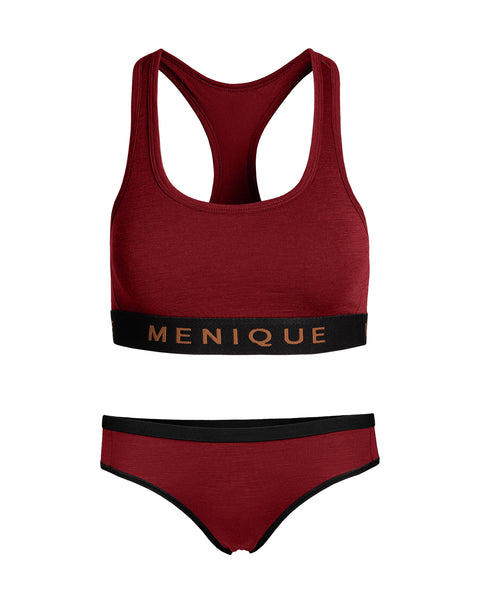 A flat-lay product shot of a matching women's underwear set in a deep red or royal cherry color, displayed against a pure white background. The set includes a racerback sports bralette and bikini-style briefs. Both pieces feature a contrasting black elastic band with the brand name "MENIQUE" woven in light brown text.