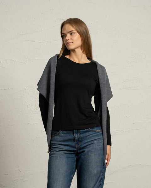 Dark gray knit merino bandana worn as a hooded scarf on a woman.