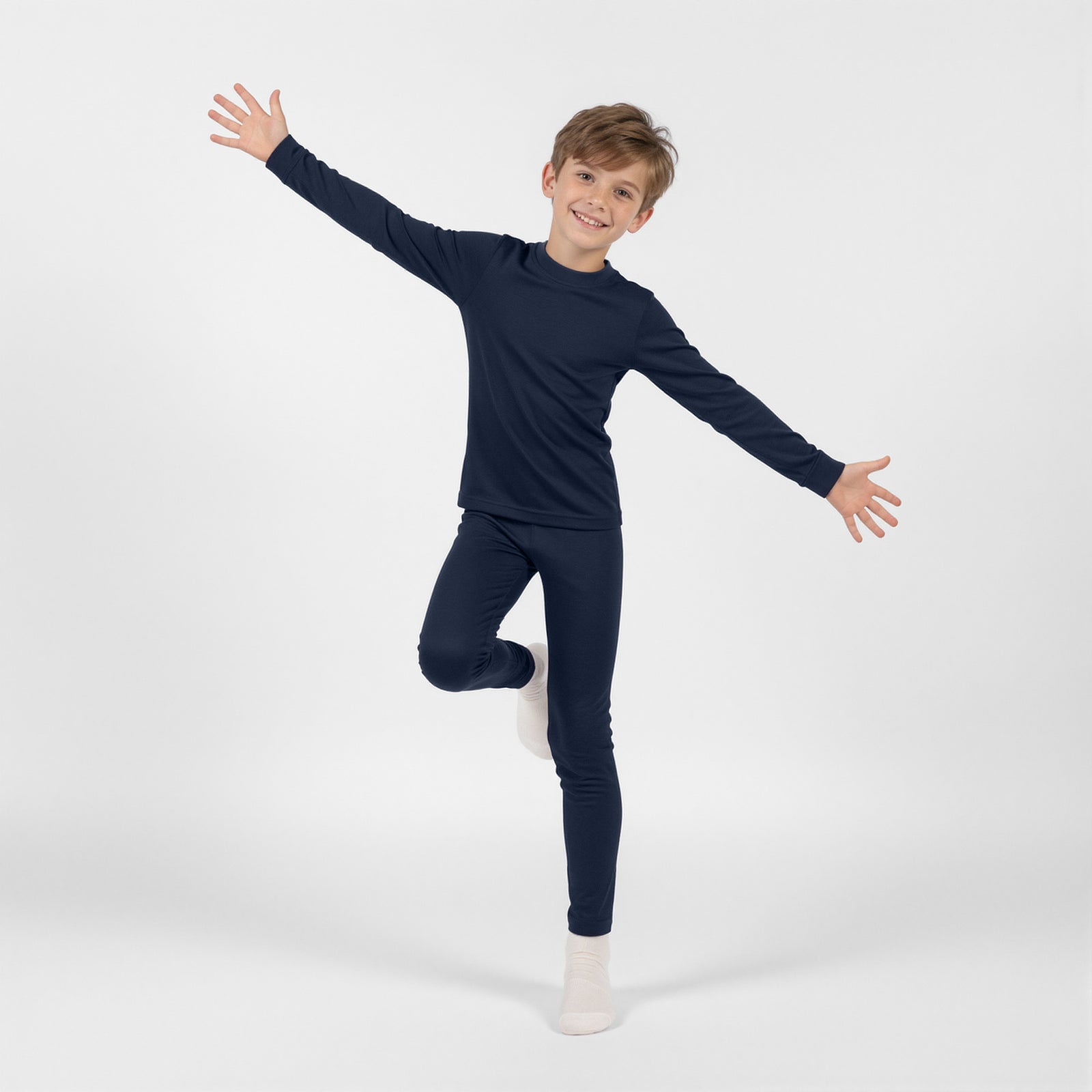 A young girl modeling a long-sleeved navy blue thermal top, standing with one hand on her hip against a white background.