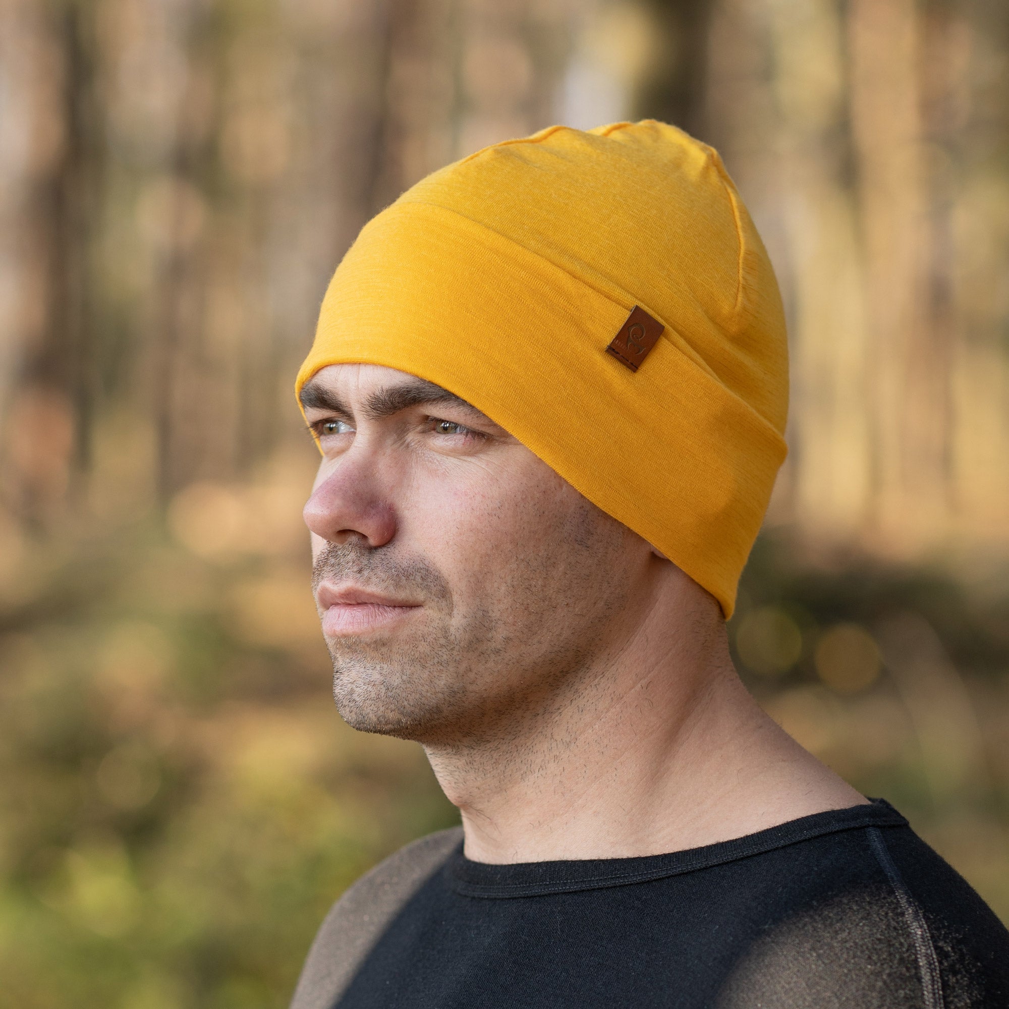 the menique men's merino beanie hat in the color power mango, in a white background.